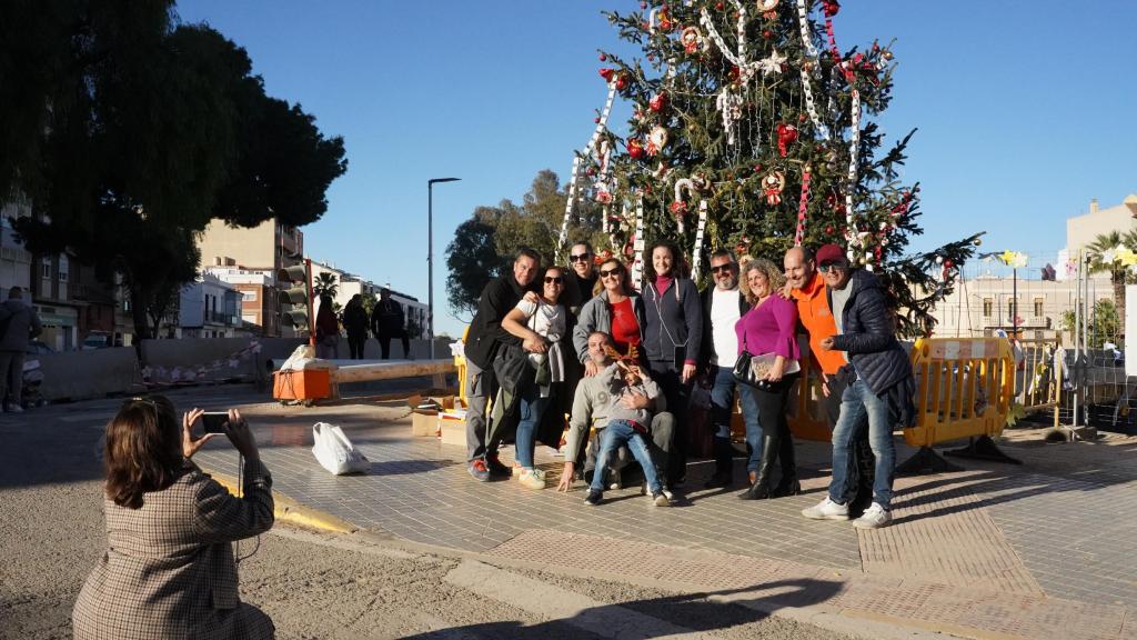 La familia Ferrandis se toma una fotografía junto al árbol de Navidad de Paiporta durante la tarde de Nochebuena.