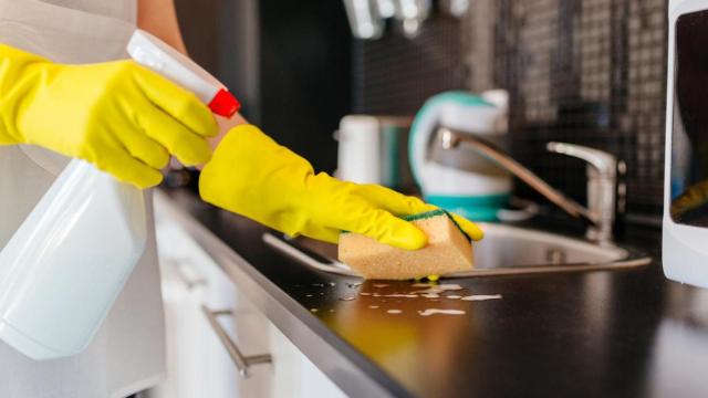 Una persona limpiando la encimera de la cocina