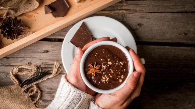 Mujer con una taza de chocolate caliente entre las manos.