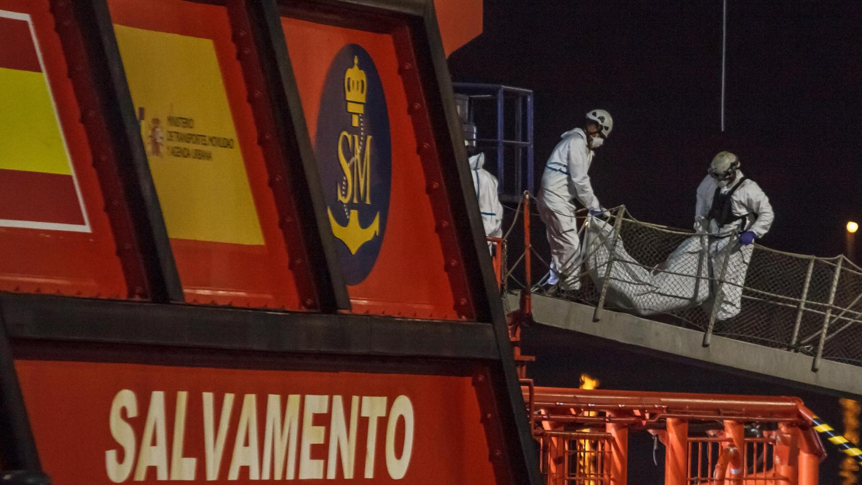 Dos miembros de Salvamento Marítimo levantan uno de los cadáveres de una patera en Canarias en una imagen de archivo.