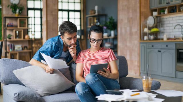 Fotografía de una pareja en su casa gestionando las facturas.