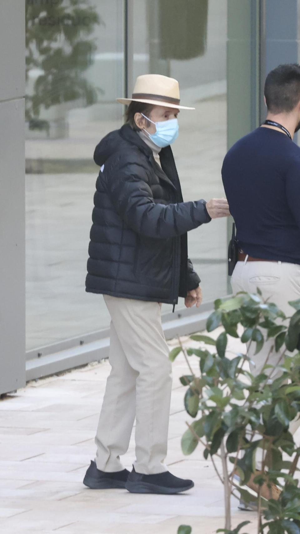 Con sombrero, mascarilla y caminando. Así ha salido Raphael del centro médico.