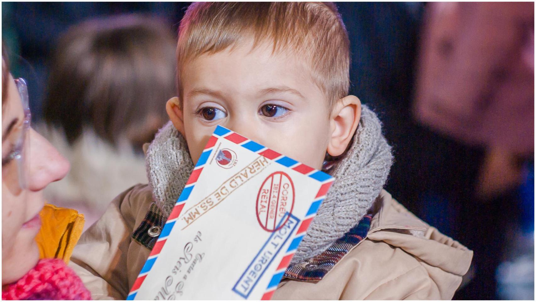 Un niño espera para darle su carta a los Reyes Magos