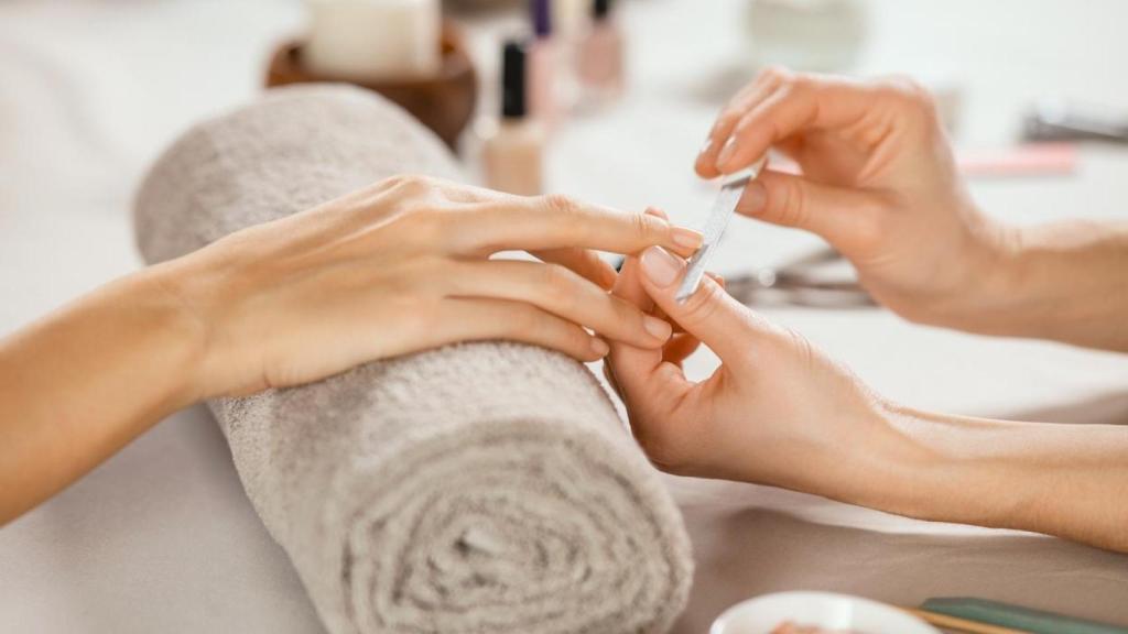 Mujer haciéndose la manicura con una especialista.