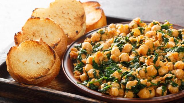 Plato de garbanzos junto a rebanadas de pan.