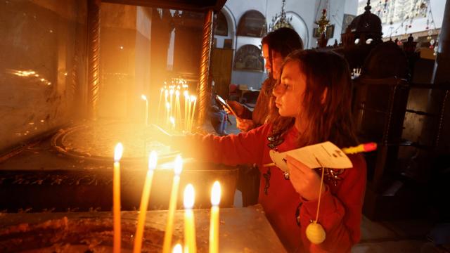 Creyentes encienden velas en la Iglesia de la Natividad en Belén, en la Cisjordania ocupada por Israel