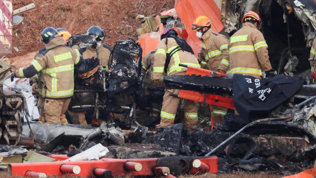 Los equipos de rescate participan en una operación de salvamento en el lugar donde un avión se estrelló después de salirse de la pista en el Aeropuerto Internacional de Muan, en Muan, Corea del Sur.