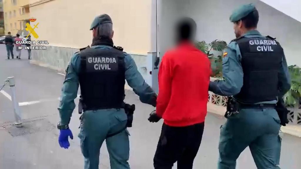 La Guardia Civil traslada a uno de los detenidos en el centro de Las Raíces, en Tenerife.