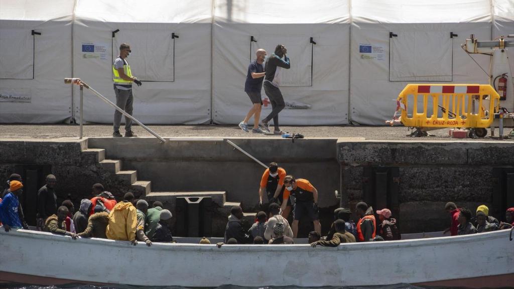 Los equipos de emergencias ayudan a desembarcar a varios migrantes, en el puerto de La Restinga, en El Hierro.