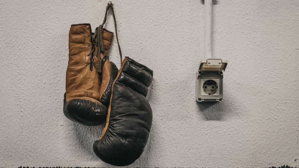 Los guantes de Rabha Lyazidi cuelgan de una pared del gimnasio en el que practica boxeo.