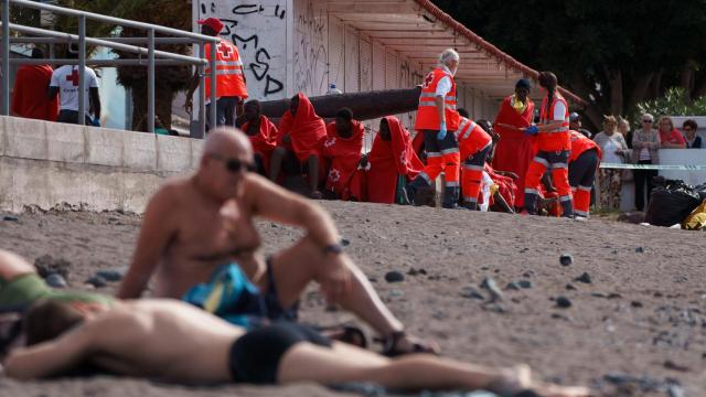 Varios migrantes, entre ellos algunos menores, atendidos en la playa de Las Galletas (Tenerife), tras la llegada del primer cayuco de 2025.