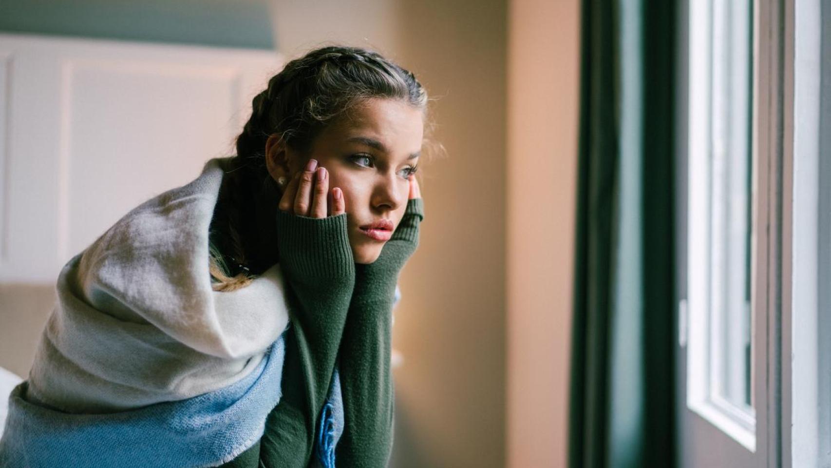 Imagen de una chica mirando por la ventana.