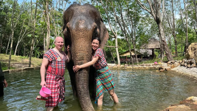 Dos turistas en un parque de elefantes en Tailandia.