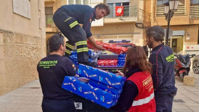 Bomberos de Málaga descargando los regalos en Valencia.