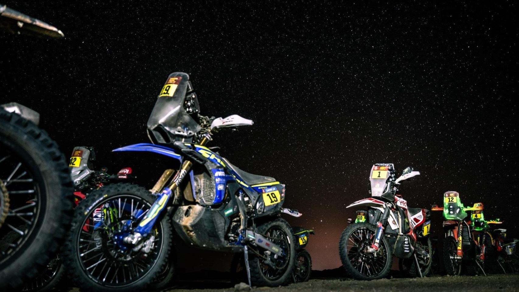 Las motos de varios pilotos del Rally Dakar bajo las estrellas del desierto de Arabia Saudí.