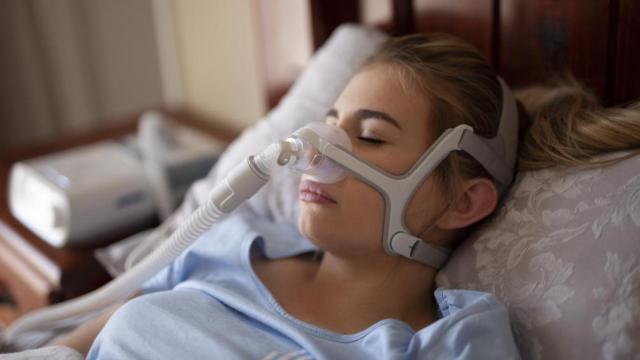 Una mujer con apnea obstructiva del sueño utiliza una máquina para mitigarla.