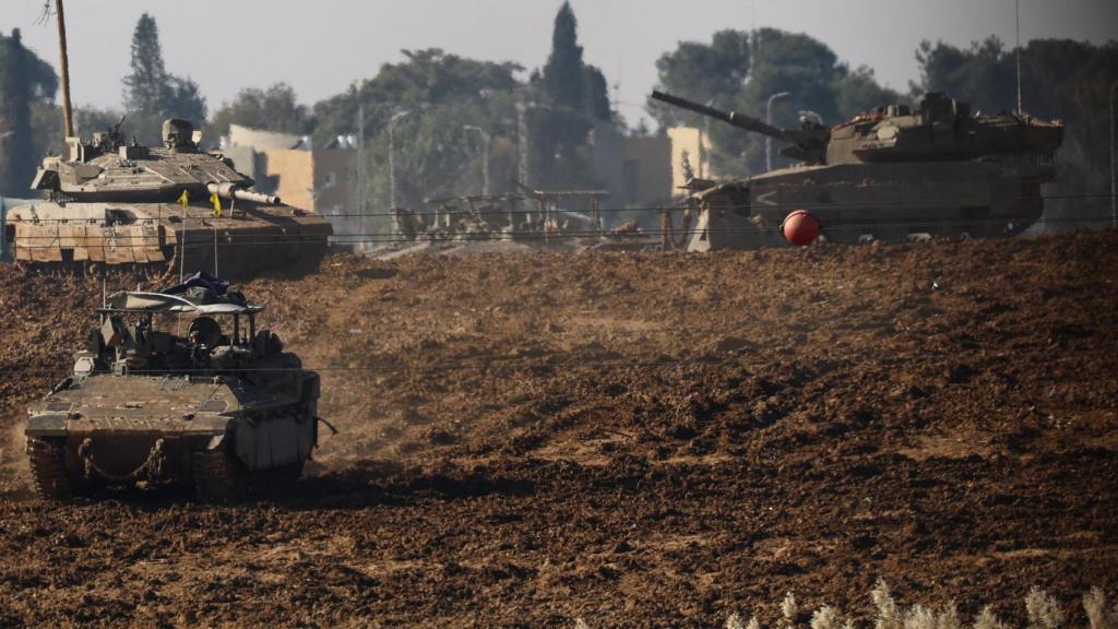 Vehículos militares israelíes operan en una base cerca de la frontera con Gaza este lunes.