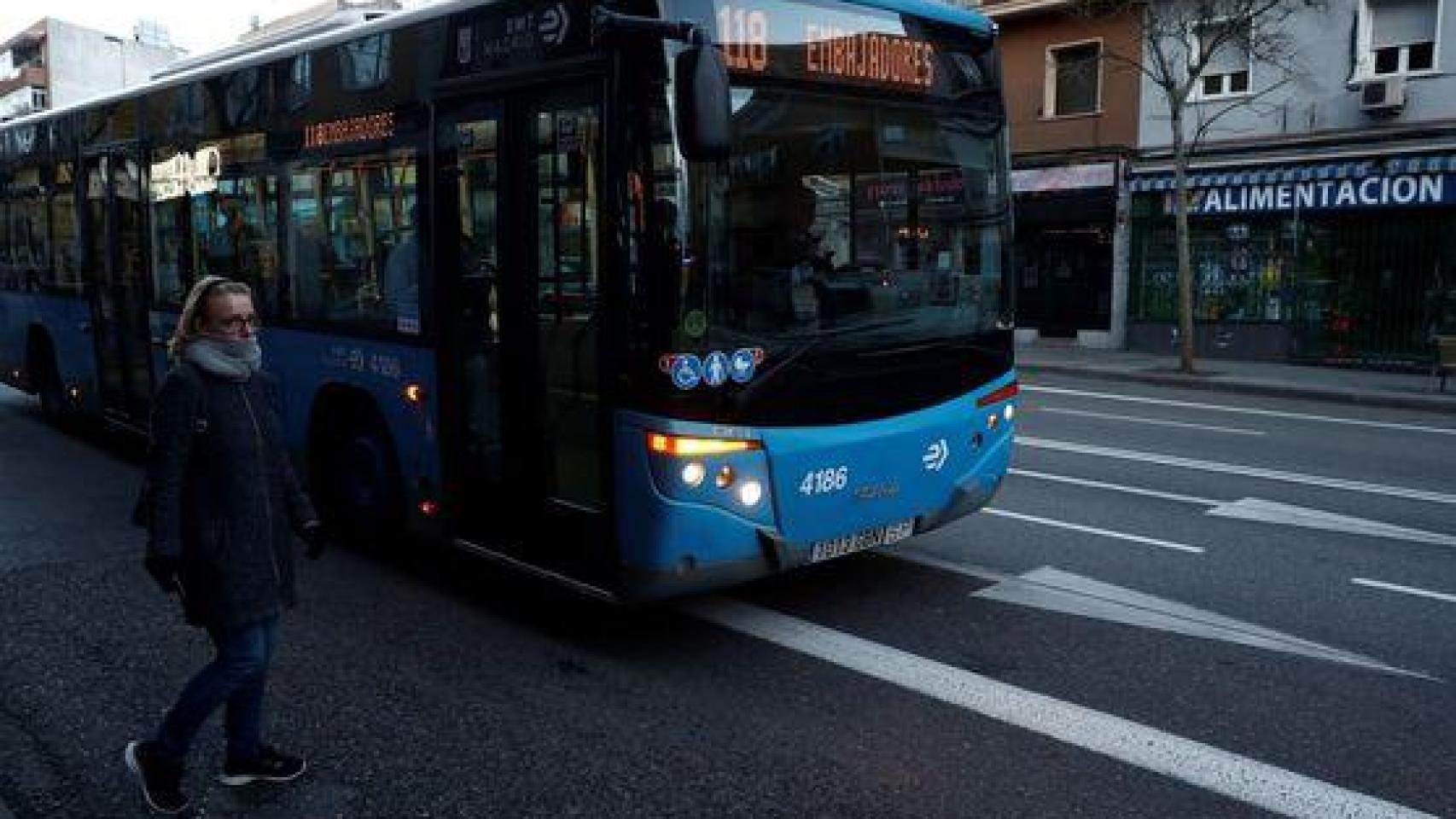 Una mujer esperando a subirse a un autobús en Madrid.