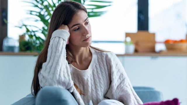 Mujer con aspecto cansado en el sofá.