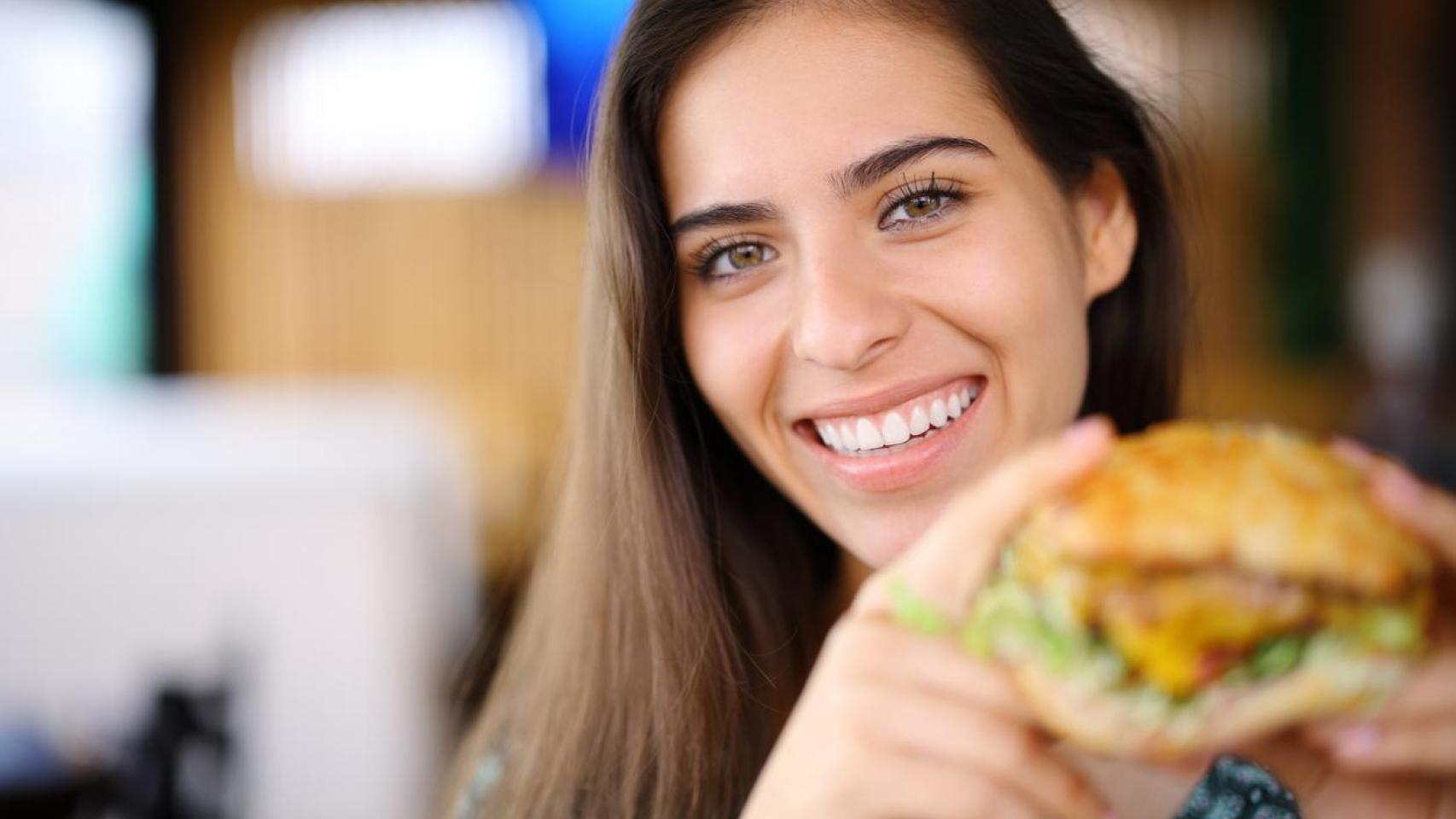 Mujer sosteniendo un bocadillo.