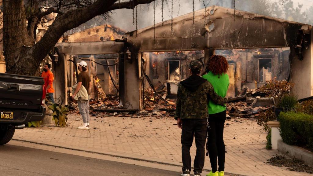 Una pareja observa su casa afectada por el incendio