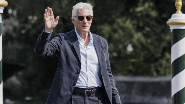 Richard Gere saluda a unos fotógrafos.