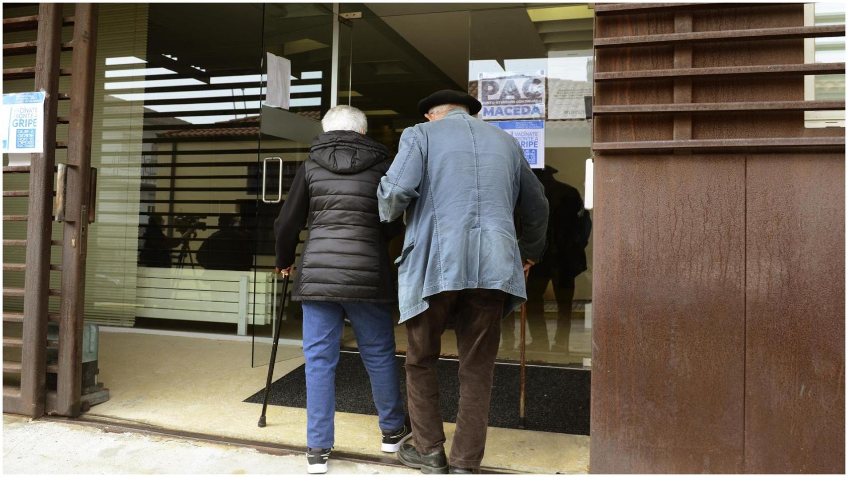 Una pareja de ancianos a su llegada a un Centro de Salud para recibir la vacuna contra la gripe