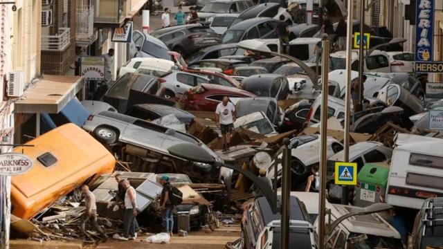 Vehículos amontonados en una calle de Picanya tras las inundaciones. Efe / Biel Aliño