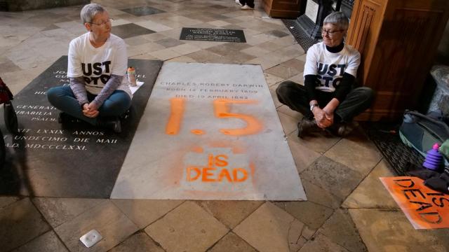 Activistas climáticos de 'Just Stop Oil' protestan después de pintar sobre la tumba de Charles Darwin en la Abadía de Westminster, en Londres.