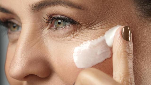 Mujer aplicándose crema facial.