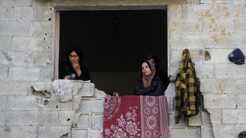 Mujeres gazatíes en un edificio medio en ruinas.