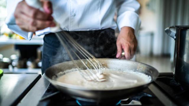 Un chef prepara salsa bechamel