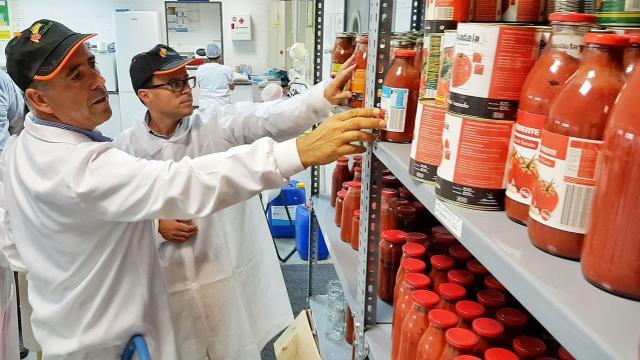 Miguel Ángel Gallardo, de fondo, durante una visita a una planta extremeña de procesamiento de tomates.