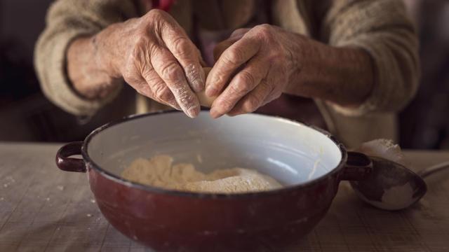 Una mujer mayor cocinando.