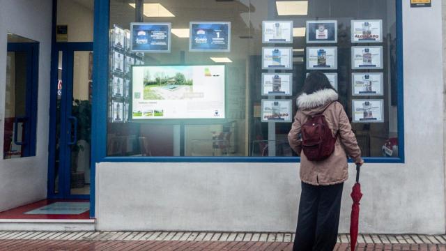 Una mujer observa las ofertas de una inmobiliaria