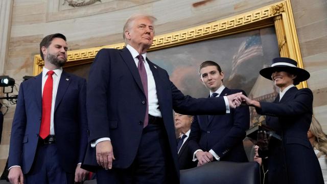 El presidente de Estados Unidos, Donald Trump, toma la mano de su esposa Melania Trump, mientras su hijo Barron Trump y el vicepresidente JD Vance observan después de prestar juramento.