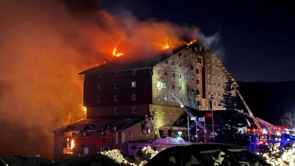 Los bomberos tratan de apagar el fuego  que devoraba el hotel.