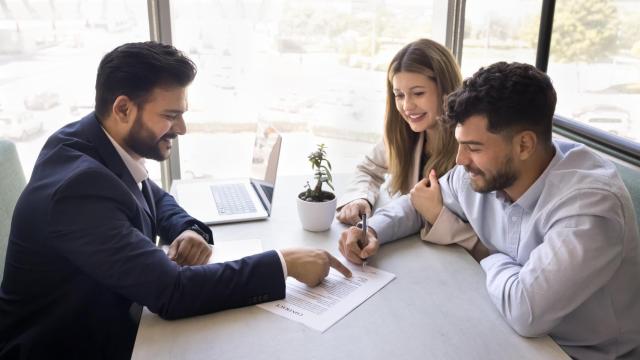 Una pareja pide información a un agente inmobiliario, en una imagen de Shutterstock.