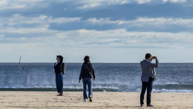 Varias personas pasean por la playa de la Malvarrosa durante este lunes en el que la borrasca Herminia ha hecho activar el aviso naranja y amarillo en la Comunitat Valenciana. Efe / Ana Escobar