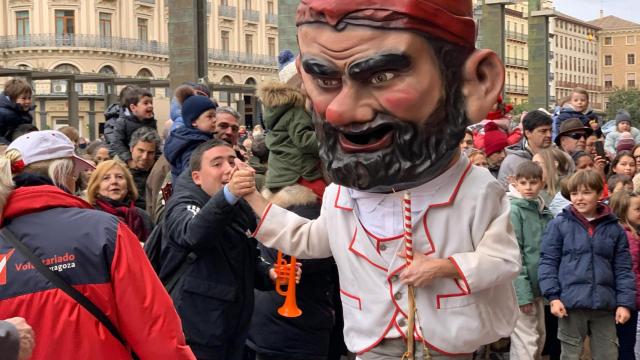 Uno de los cabezudos saluda a los niños en la plaza del Pilar.