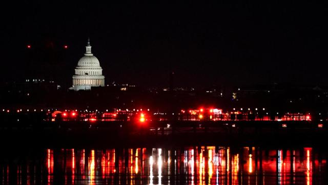 Las luces de los servicios de emergencia se reflejan en las aguas del Potomac.