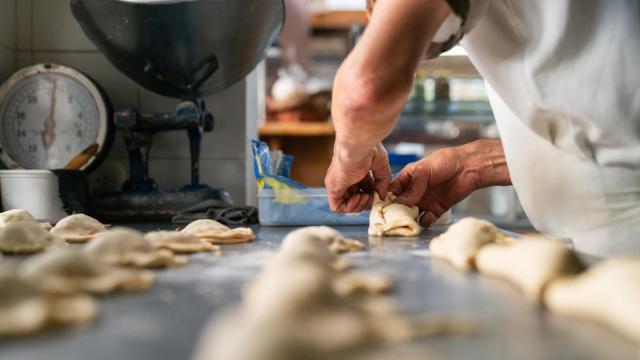 Primer plano de un panadero haciendo bartolillos madrileños.