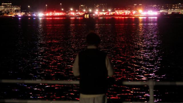 Una persona observa los trabajos de rescate en el río Potomac.