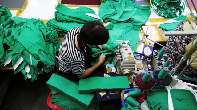 Fotografía de una mujer en una fábrica de textil.