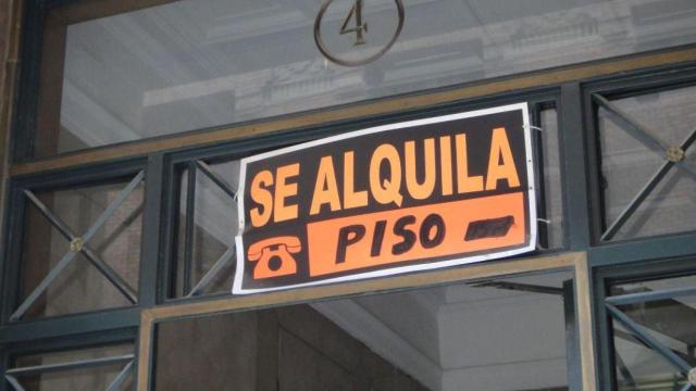 Cartel de un piso en alquiler en un balcón.