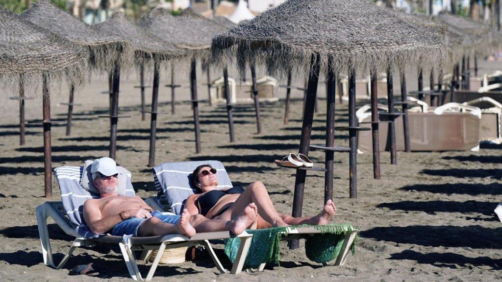 Dos turistas, tumbados en hamacas, en Málaga.