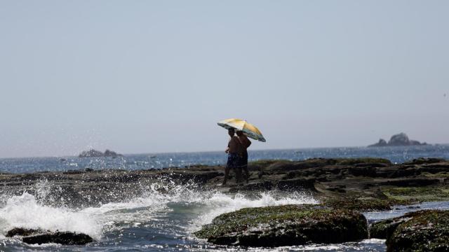 Personas pasean por una playa durante una ola de calor en Chile el pasado enero.