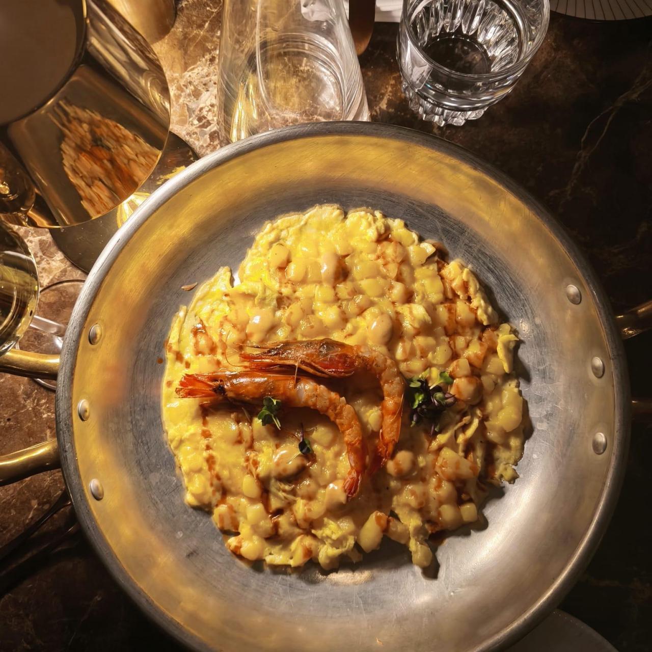 La tortilla abierta de patatas con gamba roja, espinacas y cremoso de piñones.