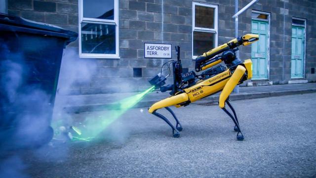 Un perro robot apuntando a una bomba para desactivarla.