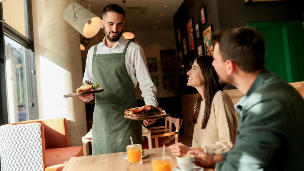 Un camarero en un restaurante, en una imagen de Shutterstock.